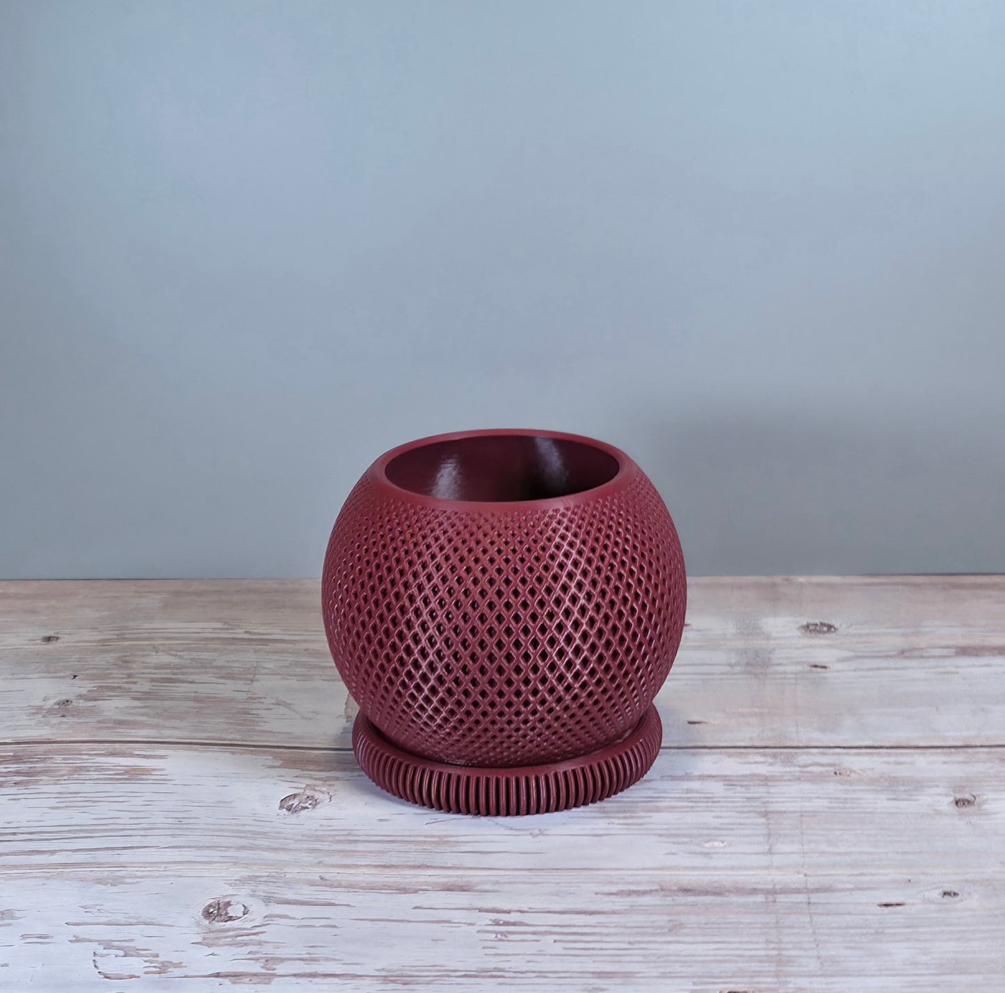 Maroon Mesh Planter with Round Drip Tray against Light Grey Background