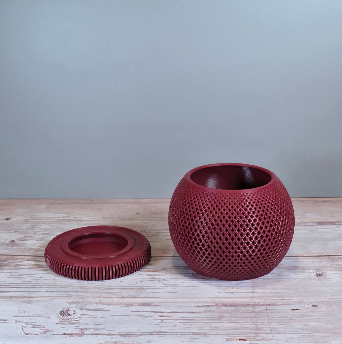 Maroon Mesh Planter with Round Drip Tray against Light Grey Background