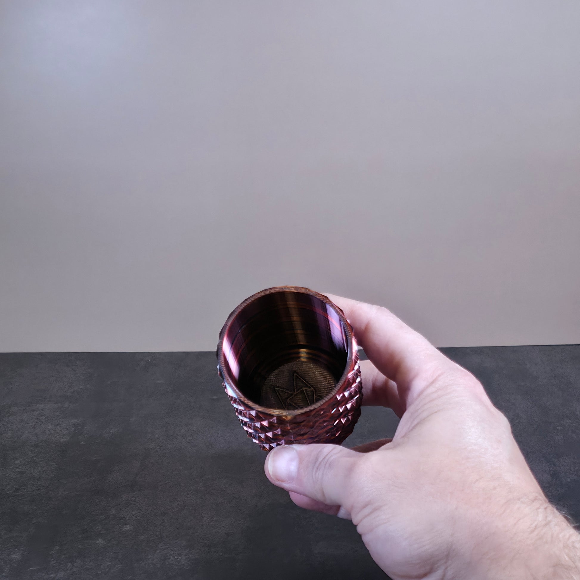 Red Cup with Black Stripes and Geometric Texture against Stone Background