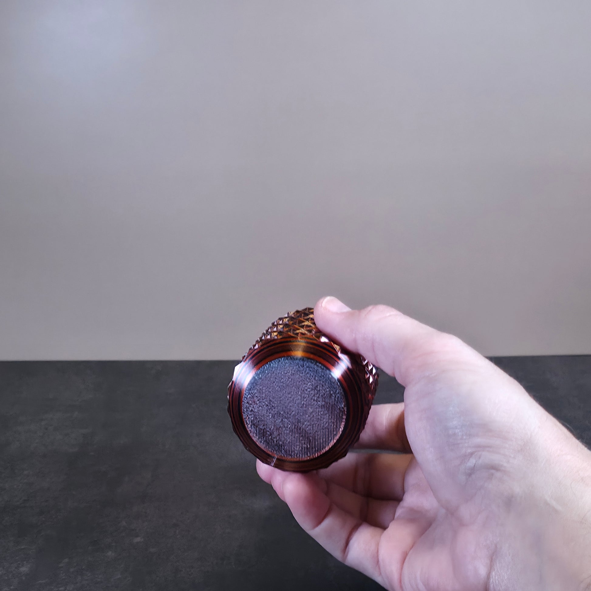 Red Cup with Black Stripes and Geometric Texture against Stone Background