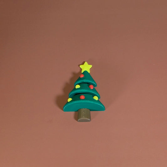 Toy Christmas tree with a star on top against a brown background