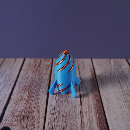 Blue and orange rocket toy on a wooden surface with a purple background