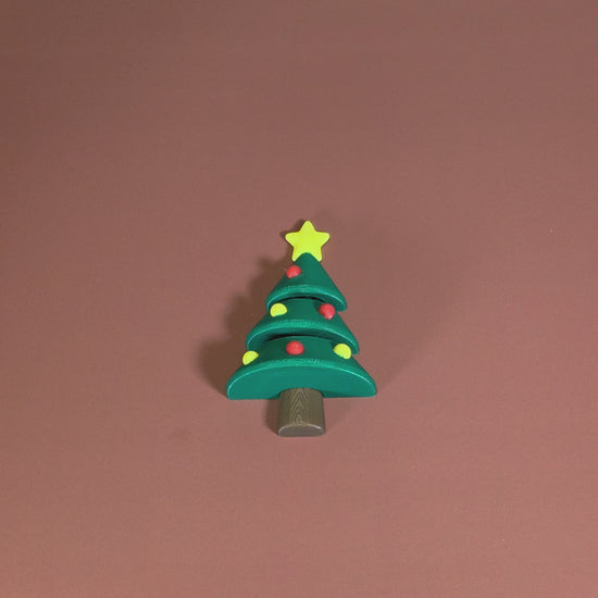 Toy Christmas tree with a star on top against a brown background